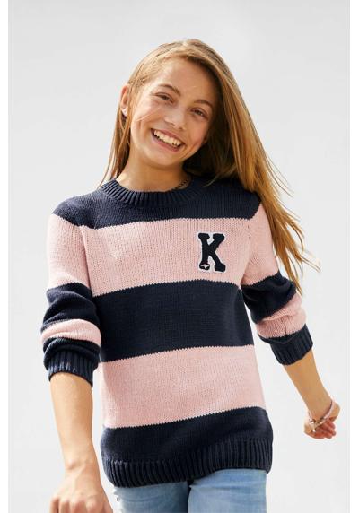 Вязаный свитер в модном образе в полоску.